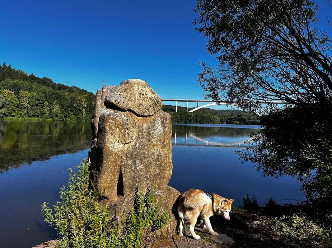 Froschgrundsee - Idyllischer Badesee mit der 270m ICE Bogenbrücke 6 Der Start des 2,6Km langen Weges an der Steinskulptur mit Blick auf die Brücke.